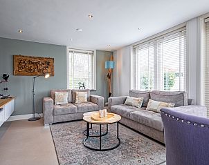 Gezellige woonkamer in Bungalow Postweg 109, De Cocksdorp, Texel. Comfortabele zitruimte met veel daglicht op de Waddeneilanden.