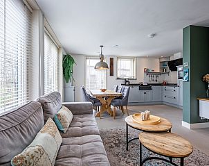 Gezellige woonkamer in Bungalow Postweg 109, De Cocksdorp, Texel. Comfortabel vakantiehuis met moderne inrichting en veel natuurlijk licht.