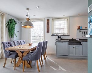 Gezellige eetkamer in Bungalow Postweg 109, De Cocksdorp, Texel. Geniet van comfort en stijl in dit vakantiehuis op de Waddeneilanden.