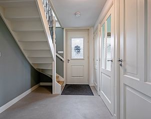 Ingang van Bungalow Postweg 109 in De Cocksdorp, Texel, met moderne trap en lichte hal in deze sfeervolle vakantiewoning op de Waddeneilanden.