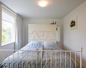 Sfeervolle slaapkamer in Bungalow Postweg 109, De Cocksdorp, Texel, met comfortabel tweepersoonsbed en rustgevend uitzicht op de natuur.