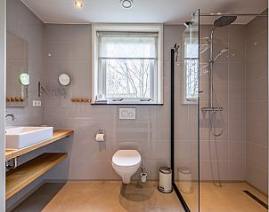 Moderne badkamer in Bungalow Postweg 109, De Cocksdorp, Texel. Luxe vakantiehuis met ruime douche en elegant interieur op de Waddeneilanden.
