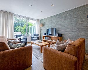 Cozy living room in Holiday home Slufterhoek 132, De Cocksdorp, Texel, with comfortable sofas and views of the garden