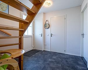 Entrance hall of Holiday home Slufterhoek 132, Texel, with wooden staircase and stylish furnishings