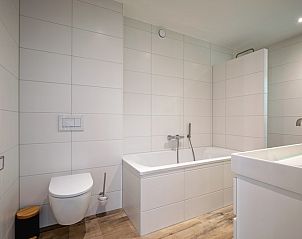 Stylish bathroom with bath in Holiday home Slufterhoek 104, De Cocksdorp Texel, for a relaxing stay.
