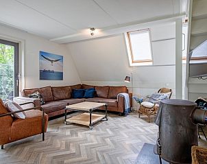 Sonniges Wohnzimmer im Ferienhaus Blommetjes Buiten, De Cocksdorp Texel, mit modernem Mobiliar und Holzofen.