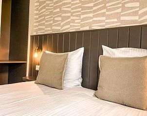 Gezellige slaapkamer van Huisje in De Cocksdorp, Texel, met luxe beddengoed en stijlvolle decoratie.