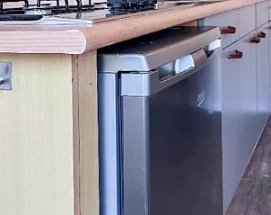 Keukenapparatuur in Huisje in De Cocksdorp, Texel, met moderne koelkast en kookplaat.