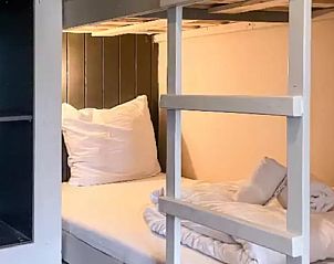 Knusse slaapruimte in Huisje in De Cocksdorp, Texel, met stapelbed en zachte kussens.