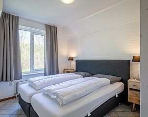 Schlafzimmer im Ferienhaus Schelpenoord 135, De Cocksdorp, Texel mit Blick auf die Natur.