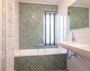 Luxurises Badezimmer mit Badewanne im Ferienhaus Schelpenoord 135, De Cocksdorp, Texel.