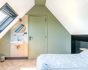 Schlafzimmer mit Dachfenster im Ferienhaus in De Cocksdorp Texel fr natrliches Licht.