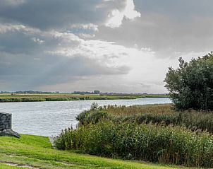 Der Blick durch das Holzfenster auf die Landschaft im Ferienhaus in De Cocksdorp, Texel, bietet einzigartige Perspektiven.