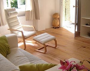 Bright living room in Cottage in De Cocksdorp, Texel, with comfortable chairs and natural light.