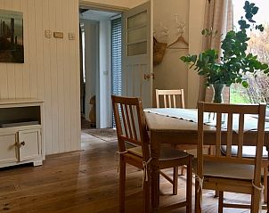 Dining area in Cottage in De Cocksdorp, Texel, overlooking green surroundings and modern furnishings.