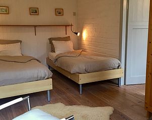 Comfortable bedroom with two beds in Cottage in De Cocksdorp, Texel, ideal for a relaxing stay.