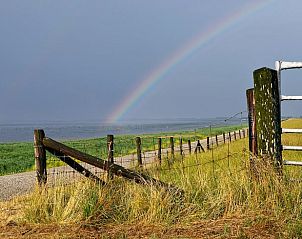 Rainbow above the dike at Cottage in De Cocksdorp, Texel, overlooking the Wadden Sea.