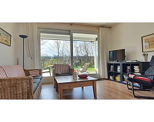 Cozy living room overlooking the garden in Bungalowpark Slufteroord - Holiday home Slufteroord 312, Texel.