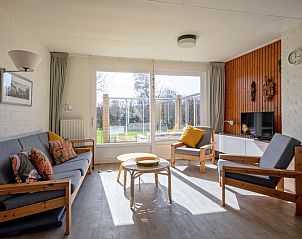 Helles Wohnzimmer im Ferienhaus Slufteroord 292 mit Blick auf den Garten in De Cocksdorp, Texel.