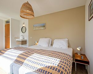 Schlafzimmer mit Holzbett und dekorativer Lampe im Ferienhaus Slufteroord 292, Texel.