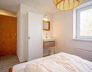 Schlafzimmer mit Waschbecken und Kleiderschrank im Ferienhaus Slufteroord 292, De Cocksdorp, Texel.