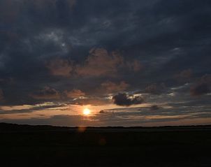 Atemberaubender Sonnenuntergang ber den Feldern im Ferienhaus in De Cocksdorp, Texel, fr ein entspanntes Erlebnis auf den Watteninseln.