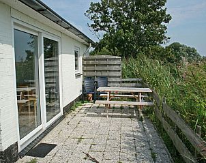 Sunny terrace at De Roggesloot vacation home in De Cocksdorp, Texel with picnic table.
