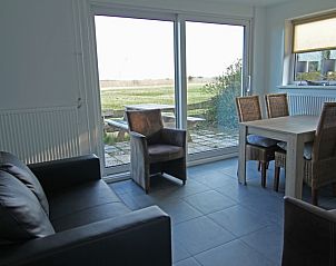 Modern living room in De Roggesloot vacation home, De Cocksdorp, Texel with views of the countryside.