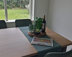 Gemtliche Essecke im Ferienhaus Bungalowpark Slufteroord - Duinzicht de Slufter, De Cocksdorp Texel, mit Blick auf den Garten.