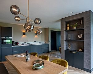 Essecke im 6-Personen-Ferienhaus in De Cocksdorp, Texel, mit luxurisem Holztisch und Designer-Beleuchtung.