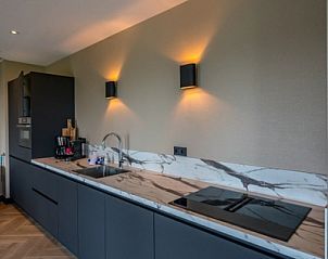 Moderne Kche in einem 6-Personen-Ferienhaus in De Cocksdorp, Texel, mit glatter Oberflche.