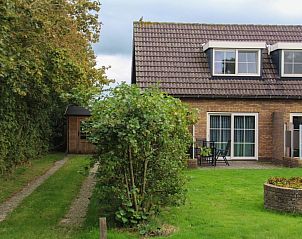 Zijaanzicht van bungalow Duif in Dennenbos Texel met groene omgeving.