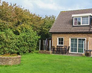 Voorzijde van bungalow Duif in Dennenbos Texel met groene tuin.
