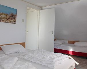 Ruime slaapkamer in bungalow Duif in Dennenbos Texel met extra bed.
