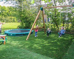 Kinderen spelen in de tuin van bungalow Duif in Dennenbos Texel, Waddeneilanden.