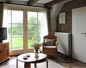 Gezellige woonkamer van Wind en Zee vakantiehuis in De Koog, Texel met tuinzicht.