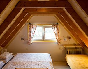 Sfeervolle slaapkamer met houten balken in Wind en Zee vakantiehuis, De Koog, Texel.