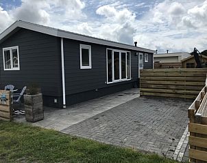 Chalet Bregkoog 231 in De Koog, Texel with paved terrace and wooden fence on Chaletpark Bregkoog.