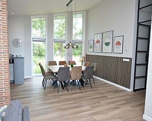 Dining area in Orchismient 49 vacation home, De Koog, Texel with large windows for stunning views of the surroundings.