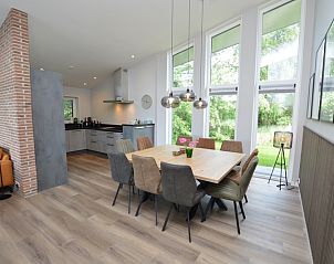 Spacious dining room of Orchismient 49 vacation home in De Koog, Texel with modern furnishings and lots of natural light.