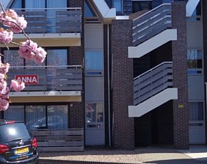 Eingang zu den Appartements Anna - Zeenevel - 9 in De Koog, Texel, mit blhenden Bumen und Parkplatz.