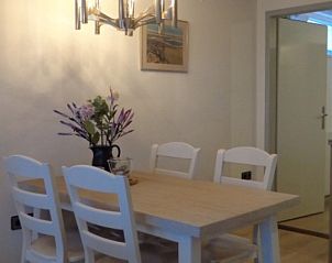 Essecke in Appartements Anna - Zeenevel - 9, De Koog, Texel, mit Holztisch und Blumen fr gemtliche Mahlzeiten.