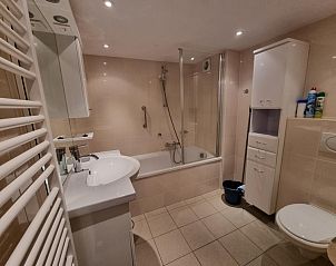 Modernes Badezimmer in Apartments Anna - Zeenevel - 9, De Koog, Texel, mit Badewanne, Dusche und stilvoller Einrichtung.