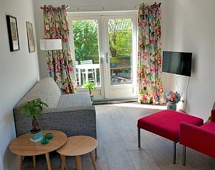 Bright living room of Huisje Quirijn, De Koog Texel overlooking the garden through French doors.