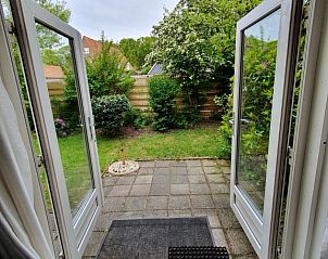 View of the green garden of Huisje Quirijn, De Koog Texel from the cottage's French doors.