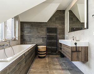 Luxury bathroom with bath in Villa 41, vacation home in De Koog, Texel, perfect for relaxation.