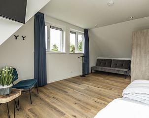 Extra spacious room in Villa 41, De Koog, Texel, with sitting area and modern furnishings.