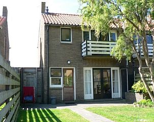 Backyard of The Duinputter vacation home in De Koog Texel with balcony and green view.
