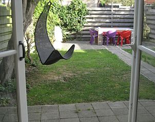 Cozy garden of The Duinputter in De Koog Texel with rocking chair and colorful chairs.