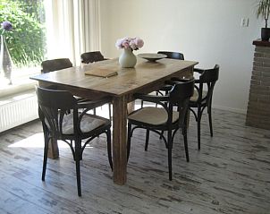 Dining room in The Duinputter vacation home De Koog Texel with wooden dining table and stylish chairs.